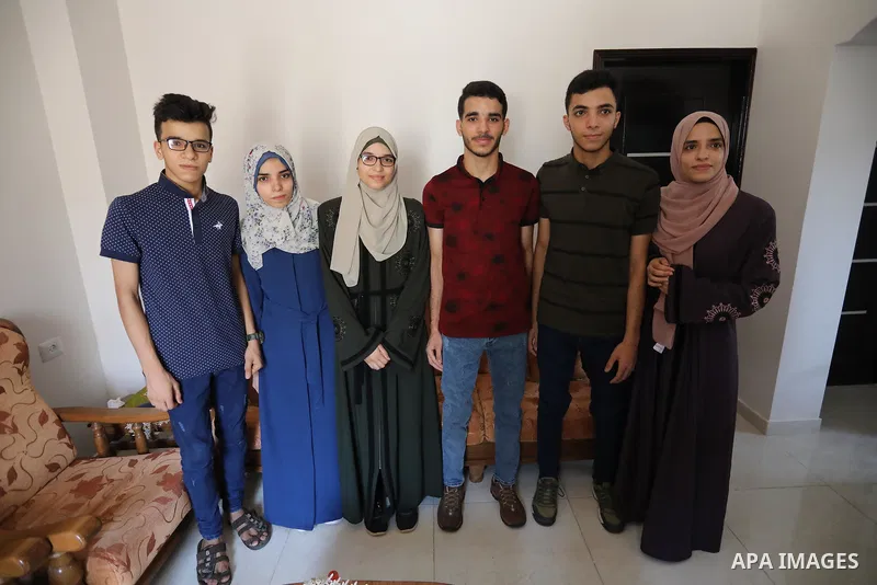 Six brothers from the Khatib family (three males and three females) celebrate with their family after their success in final exams known as ''Tawjihi'', in al-Bureij in the center of Gaza strip, on August 4, 2021. Photo...