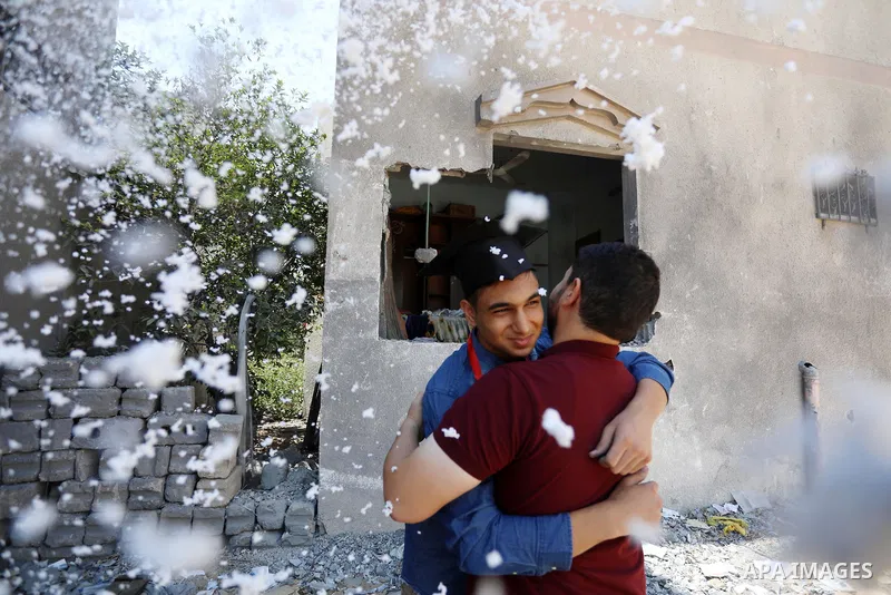 A Palestinian high school student, Yahya Al-Sakka, 94.9%, celebrates with his family after he success in final exams known as ''Tawjihi'' on the rubble of his room which was demaged by Israeli airstrikes during the recen...