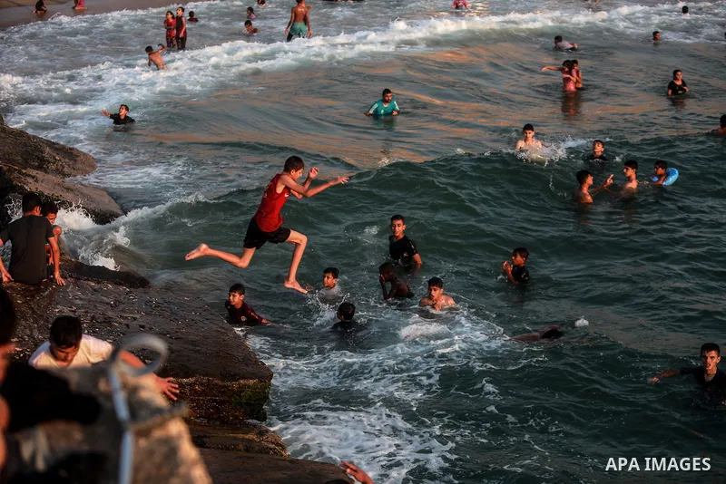 Palestinians enjoy their time at the beach of Gaza sea during a hot day on August 6, 2021. The beach is one of the few open public spaces in this densely populated city. Photo by Mohammed Dahman