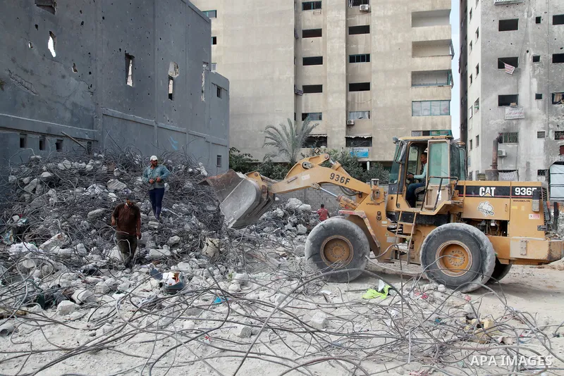 Palestinian workers remove the rubble of Jala' Tower recently destroyed by Israeli strikes in Gaza City, on August 8, 2021. Al-Sisi also promised $500 million for rebuilding Gaza, and gave directives to Egyptian state in...