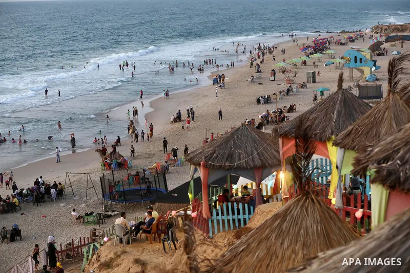 Palestinians enjoy their time at the beach of Deir al-Balah sea, in the center of Gaza Strip, during a hot day on August 11, 2021. The beach is one of the few open public spaces in this densely populated city. Photo by A...