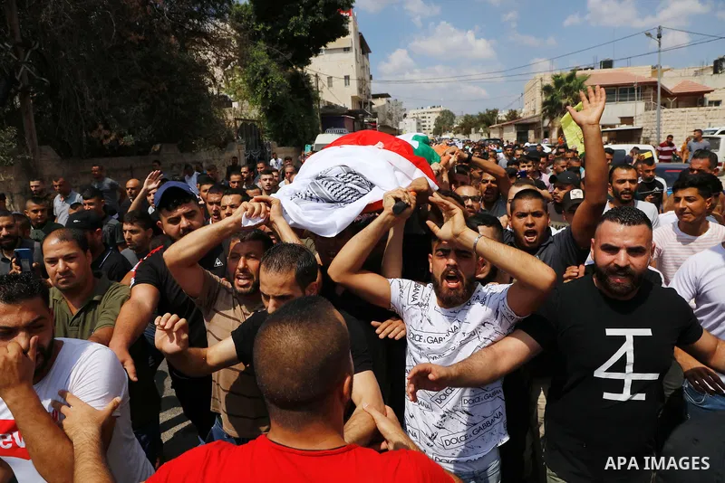 Palestinian mourners carry the body of Deyaa Sabarini, 25, who was died of his wounds after he was shot by Israeli forces last week, during his funeral, in the West Bank city of Jenin on August 12, 2021. Photo by Oday Da...