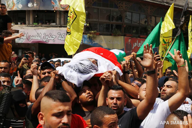 Palestinian mourners carry the body of Deyaa Sabarini, 25, who was died of his wounds after he was shot by Israeli forces last week, during his funeral, in the West Bank city of Jenin on August 12, 2021. Photo by Oday Da...