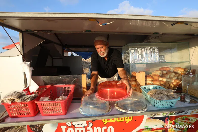 Palestinian graduates work on a small cafe "Tomanco", on the beach of the Mediterranean sea in Deir al-Balah in the central Gaza Strip, on August 14, 2021. Palestinian Abu Shadi Toman opened a small cafe on the beach of...