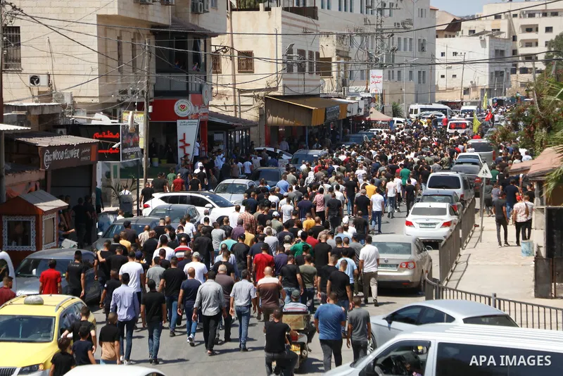 Palestinian mourners carry the body of Raed Abu Seif and Saleh Ammar, two of four Palestinians killed in clashes with Israeli security forces earlier in the day, during their funeral in the Jenin refugee camp in the nort...
