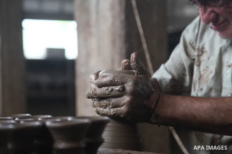A Palestinian pottery worker makes earthenware vases at a pottery workshop, in Gaza city on August 23, 2021. Pottery is an ancient and traditional craft in Gaza. Local workshops usually produce products such as bowls, pi...