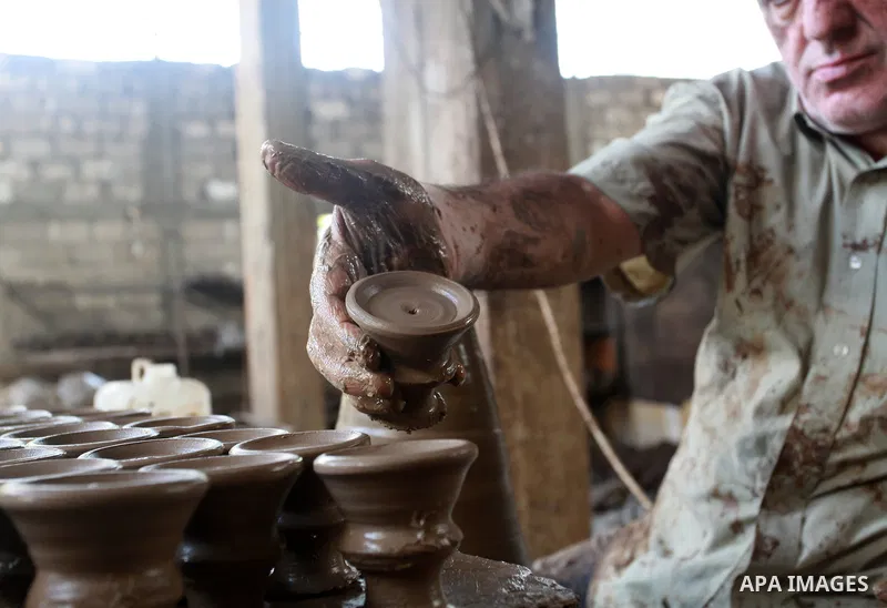 A Palestinian pottery worker makes earthenware vases at a pottery workshop, in Gaza city on August 23, 2021. Pottery is an ancient and traditional craft in Gaza. Local workshops usually produce products such as bowls, pi...