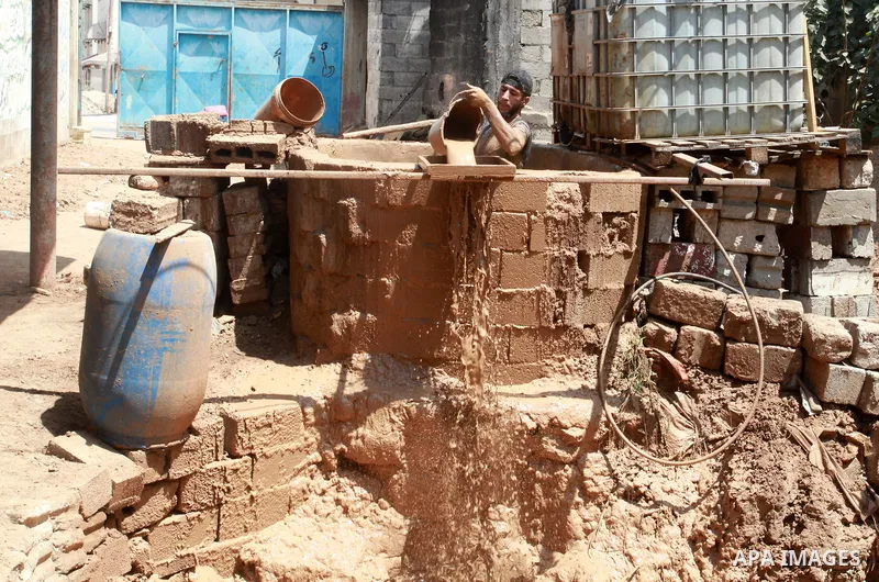 A Palestinian pottery worker makes earthenware vases at a pottery workshop, in Gaza city on August 23, 2021. Pottery is an ancient and traditional craft in Gaza. Local workshops usually produce products such as bowls, pi...