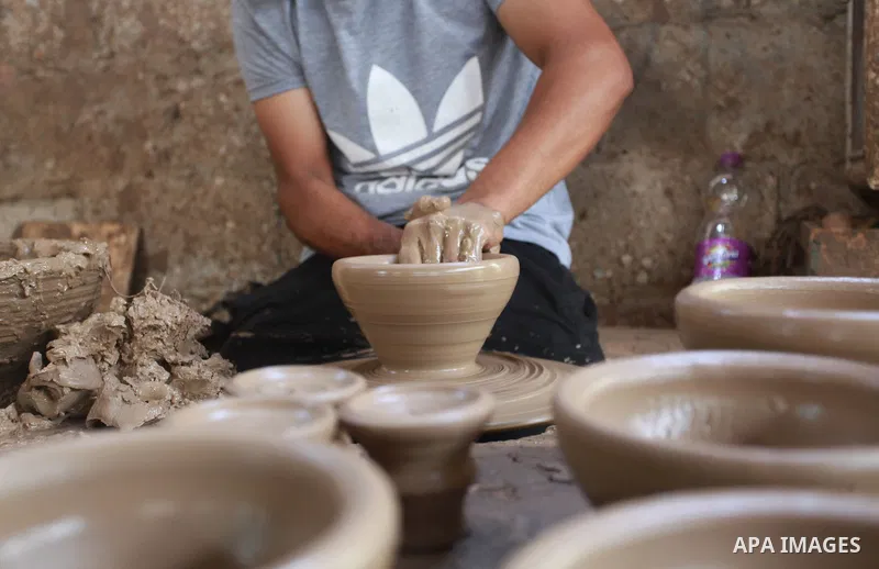 A Palestinian pottery worker makes earthenware vases at a pottery workshop, in Gaza city on August 23, 2021. Pottery is an ancient and traditional craft in Gaza. Local workshops usually produce products such as bowls, pi...