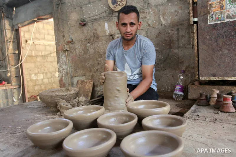 A Palestinian pottery worker makes earthenware vases at a pottery workshop, in Gaza city on August 23, 2021. Pottery is an ancient and traditional craft in Gaza. Local workshops usually produce products such as bowls, pi...