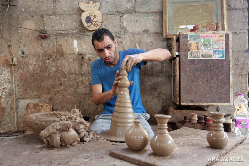 A Palestinian pottery worker makes earthenware vases at a pottery workshop, in Gaza city on August 23, 2021. Pottery is an ancient and traditional craft in Gaza. Local workshops usually produce products such as bowls, pi...