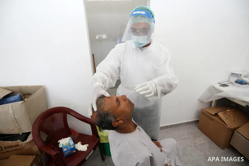 A Palestinian health worker collects a swab sample from a person for Covid-19 test, at a temporary vaccination centre set up in Khan Younis in the southern Gaza Strip on August 23, 2021. Palestinian health officials on M...