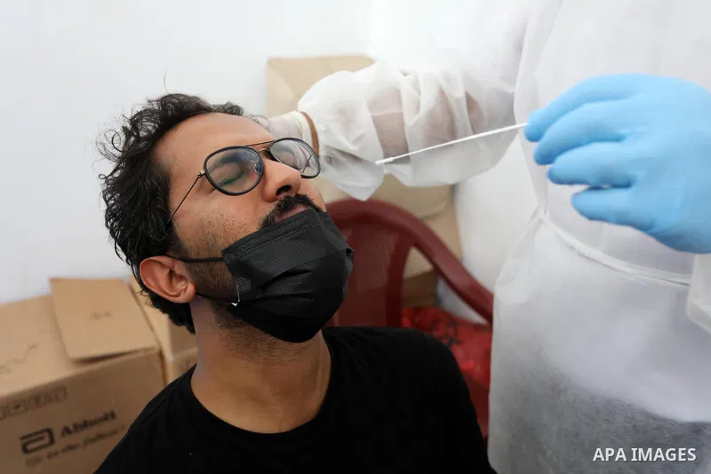 A Palestinian health worker collects a swab sample from a person for Covid-19 test, at a temporary vaccination centre set up in Khan Younis in the southern Gaza Strip on August 23, 2021. Palestinian health officials on M...