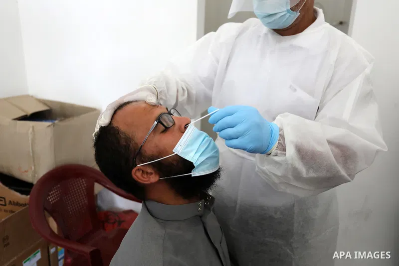 A Palestinian health worker collects a swab sample from a person for Covid-19 test, at a temporary vaccination centre set up in Khan Younis in the southern Gaza Strip on August 23, 2021. Palestinian health officials on M...