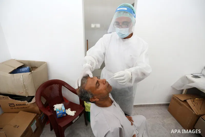 A Palestinian health worker collects a swab sample from a person for Covid-19 test, at a temporary vaccination centre set up in Khan Younis in the southern Gaza Strip on August 23, 2021. Palestinian health officials on M...