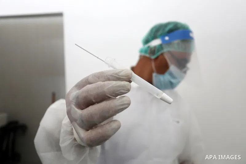 A Palestinian health worker collects a swab sample from a person for Covid-19 test, at a temporary vaccination centre set up in Khan Younis in the southern Gaza Strip on August 23, 2021. Palestinian health officials on M...