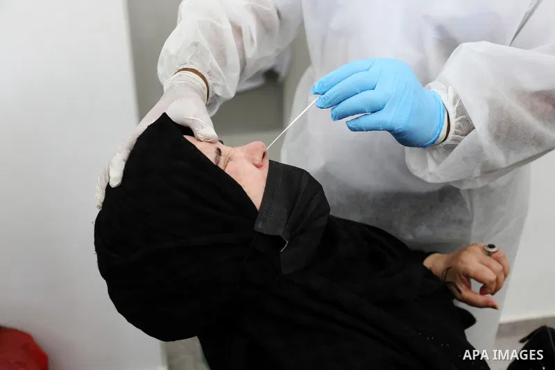 A Palestinian health worker collects a swab sample from a person for Covid-19 test, at a temporary vaccination centre set up in Khan Younis in the southern Gaza Strip on August 23, 2021. Palestinian health officials on M...