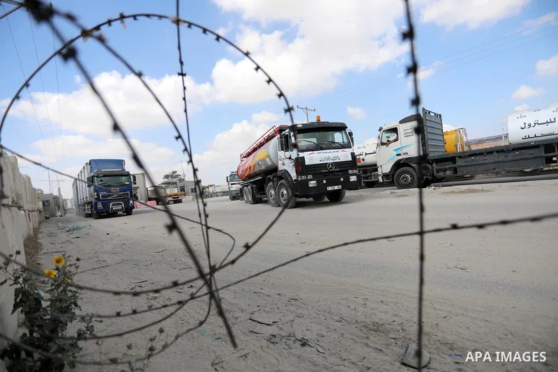 Trucks loaded with goods and fuel enter the Gaza Strip from Israel through the Kerem Shalom crossing in Rafah in the southern Gaza Strip on August 23, 2021. Israel had banned the entry of the construction materials into...