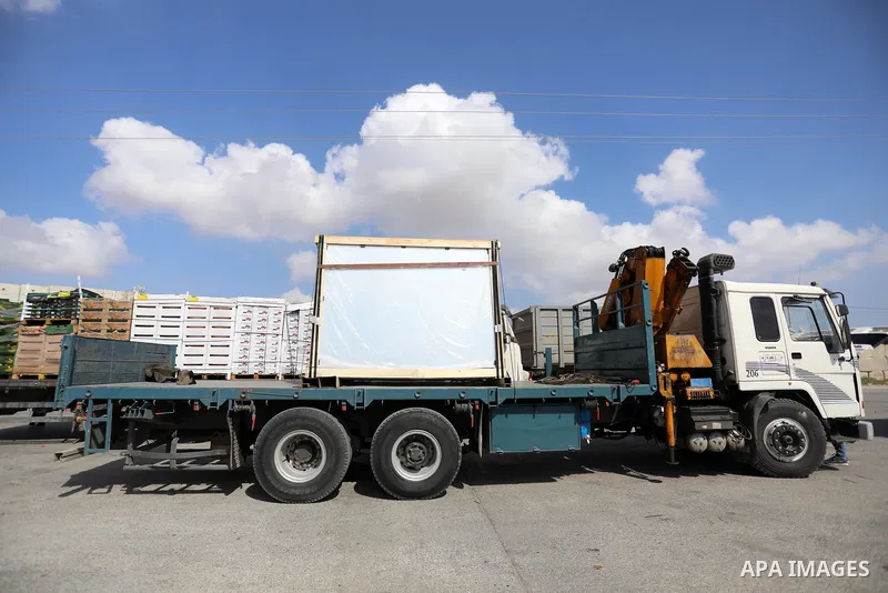 Trucks loaded with goods and fuel enter the Gaza Strip from Israel through the Kerem Shalom crossing in Rafah in the southern Gaza Strip on August 23, 2021. Israel had banned the entry of the construction materials into...