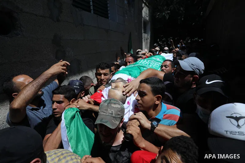 Palestinian mourners carry the body of Osama D‘aig during his funeral, in Jabalia refugee camp in the northern Gaza Strip, on August 25, 2021. He reported medical sources at al-Shifa Hospital confirming that Osama Khaled...
