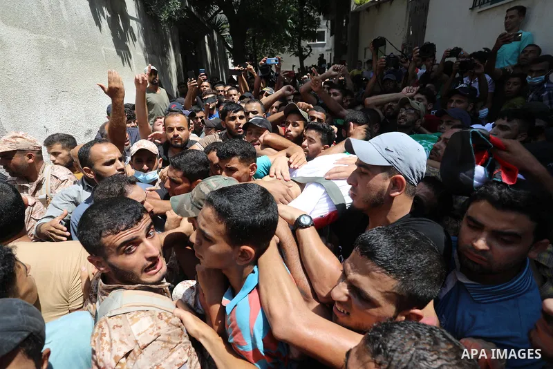 Palestinian mourners carry the body of Osama D‘aig during his funeral, in Jabalia refugee camp in the northern Gaza Strip, on August 25, 2021. He reported medical sources at al-Shifa Hospital confirming that Osama Khaled...