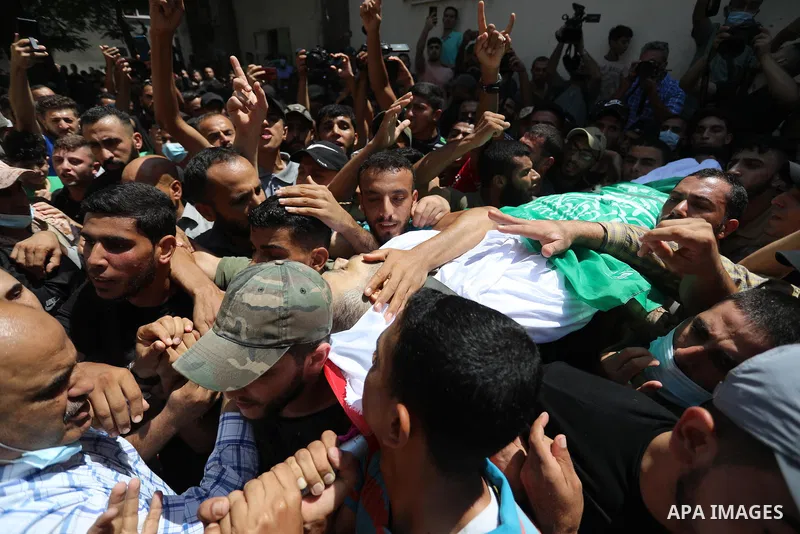 Palestinian mourners carry the body of Osama D‘aig during his funeral, in Jabalia refugee camp in the northern Gaza Strip, on August 25, 2021. He reported medical sources at al-Shifa Hospital confirming that Osama Khaled...