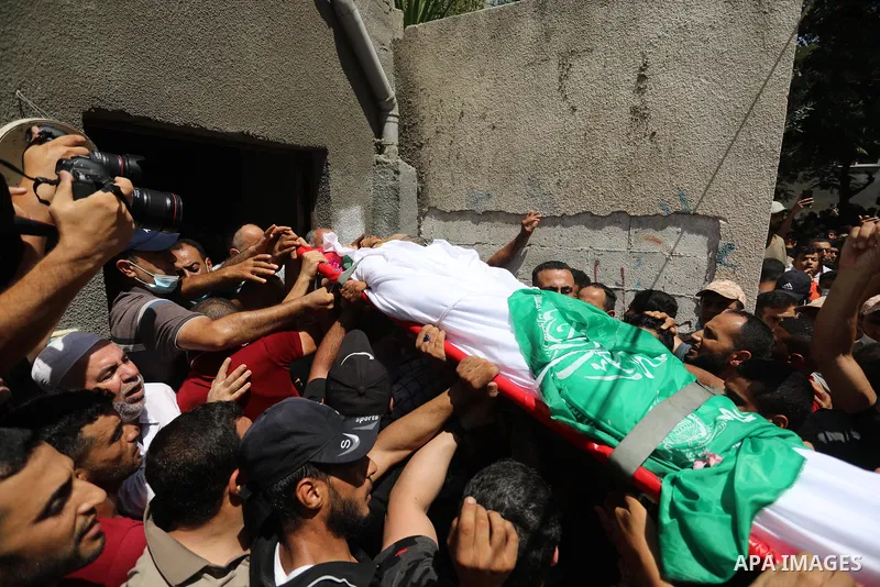 Palestinian mourners carry the body of Osama D‘aig during his funeral, in Jabalia refugee camp in the northern Gaza Strip, on August 25, 2021. He reported medical sources at al-Shifa Hospital confirming that Osama Khaled...