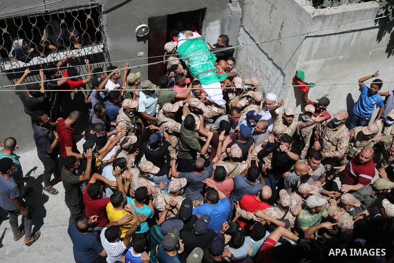 Palestinian mourners carry the body of Osama D‘aig during his funeral, in Jabalia refugee camp in the northern Gaza Strip, on August 25, 2021. He reported medical sources at al-Shifa Hospital confirming that Osama Khaled...
