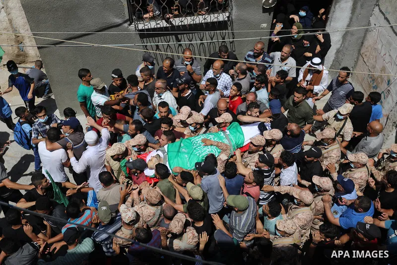 Palestinian mourners carry the body of Osama D‘aig during his funeral, in Jabalia refugee camp in the northern Gaza Strip, on August 25, 2021. He reported medical sources at al-Shifa Hospital confirming that Osama Khaled...