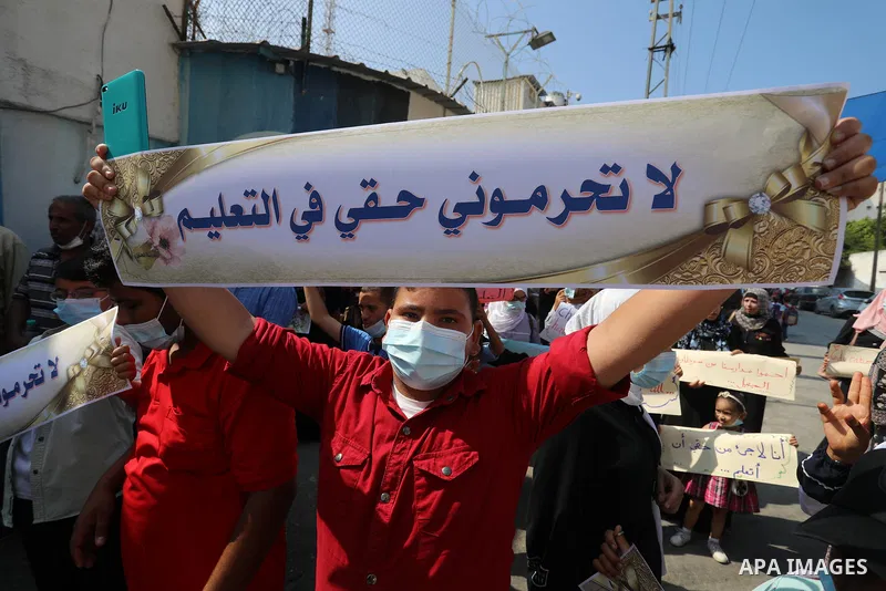 Palestinian children with disabilities hold banners during a protest to demand their right to education in front of the UNRWA gate in Gaza in front of the headquarters United Nations Relief and Works Agency (UNRWA), in G...