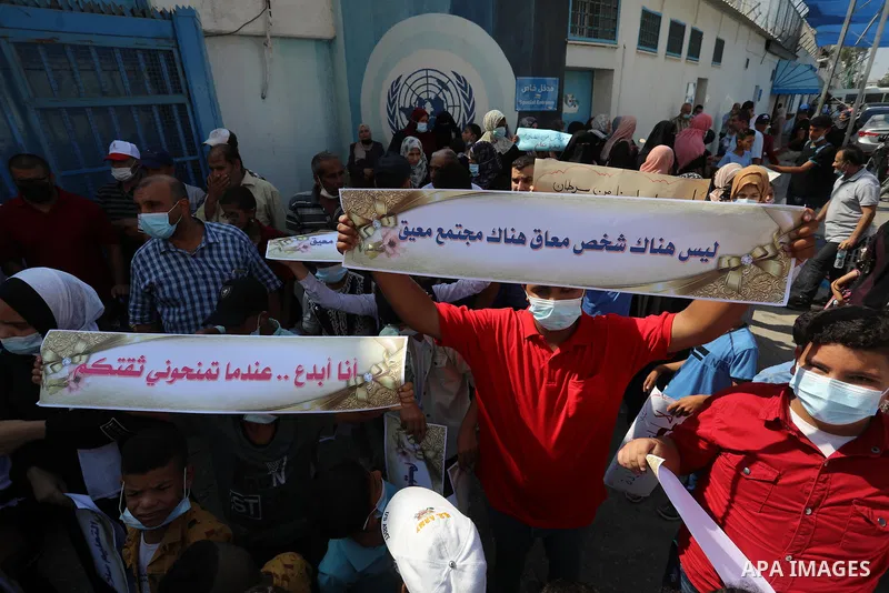 Palestinian children with disabilities hold banners during a protest to demand their right to education in front of the UNRWA gate in Gaza in front of the headquarters United Nations Relief and Works Agency (UNRWA), in G...