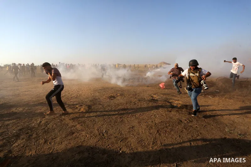 Palestinian demonstrators run from tear gas fired by Israeli security forces during a protest along the border fence, east of Khan Yunis in the southern Gaza Strip, on August 25, 2021. Palestinian groups in Gaza have ple...