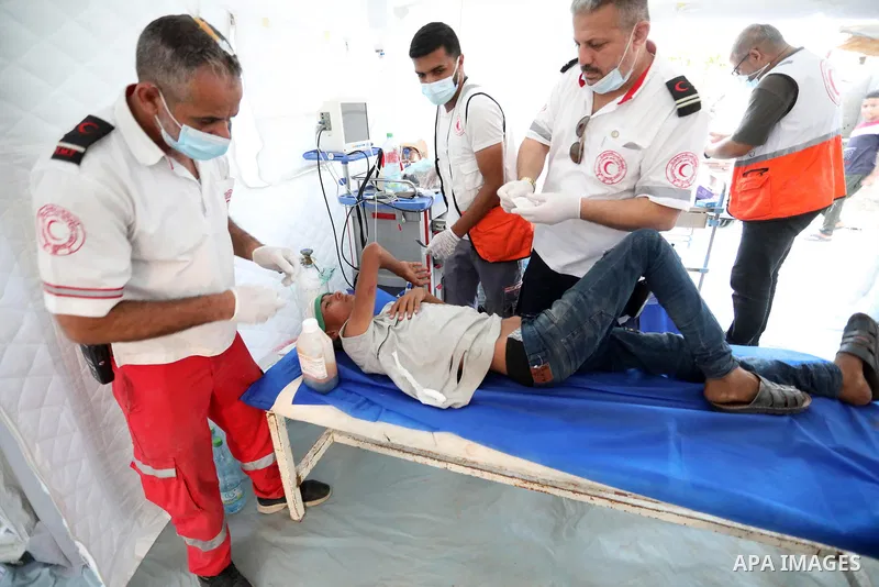 A Palestinian protester injured during clashes with Israeli security forces during a protest along the border fence, east of Khan Yunis in the southern Gaza Strip, receives treatment on August 25, 2021. Palestinian group...