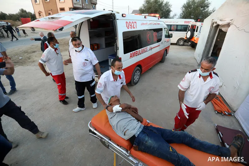 A Palestinian protester injured during clashes with Israeli security forces during a protest along the border fence, east of Khan Yunis in the southern Gaza Strip, receives treatment on August 25, 2021. Palestinian group...