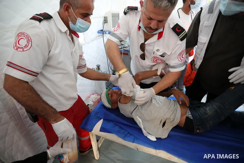 A Palestinian protester injured during clashes with Israeli security forces during a protest along the border fence, east of Khan Yunis in the southern Gaza Strip, receives treatment on August 25, 2021. Palestinian group...