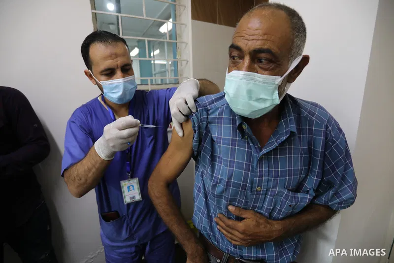 Palestinians get inoculated with a dose of the Covishield vaccine against the Covid-19 coronavirus, at a temporary vaccination centre set up, in Deir Al Balah in the center of Gaza strip on August 26, 2021. Minister of H...