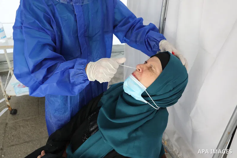 A Palestinian health worker collects a swab sample from a person for Covid-19 test, at a temporary vaccination centre set up, in Deir Al Balah in the center of Gaza strip on August 26, 2021. Three people have died of cor...