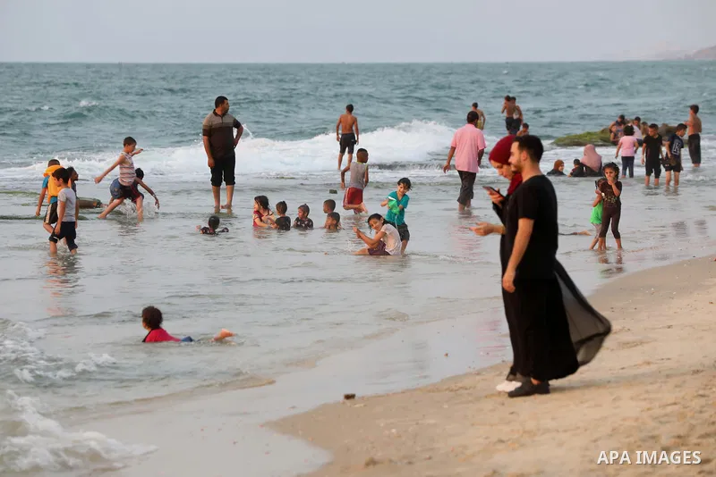 Palestinians gather at the beach in the Mediterranean Sea in Deir al-Balah in the center of Gaza Strip on August 27, 2021. The beach is one of the few open public spaces in this densely populated city. Photo by Ashraf Am...