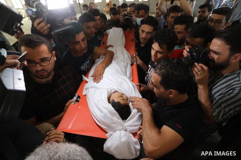 Palestinian mourners carry the body of teen Omar Abu al-Neal, who died of a wound he sustained during an anti-Israel protest at the Israel-Gaza border fence last week, during his funeral in Gaza city on August 28, 2021....