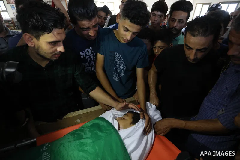 Palestinian mourners carry the body of teen Omar Abu al-Neal, who died of a wound he sustained during an anti-Israel protest at the Israel-Gaza border fence last week, during his funeral in Gaza city on August 28, 2021....