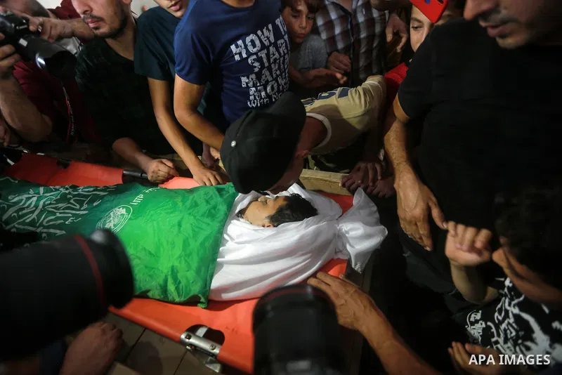 Palestinian mourners carry the body of teen Omar Abu al-Neal, who died of a wound he sustained during an anti-Israel protest at the Israel-Gaza border fence last week, during his funeral in Gaza city on August 28, 2021....