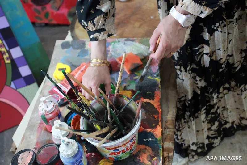 Palestinian plastic artists Mohammed Al-Hawajri and his wife Dina Matar set up an exhibition of their paintings on the roof of their house in Al-Bureij refugee camp in the center of Gaza strip, on August 28, 2021. The tw...