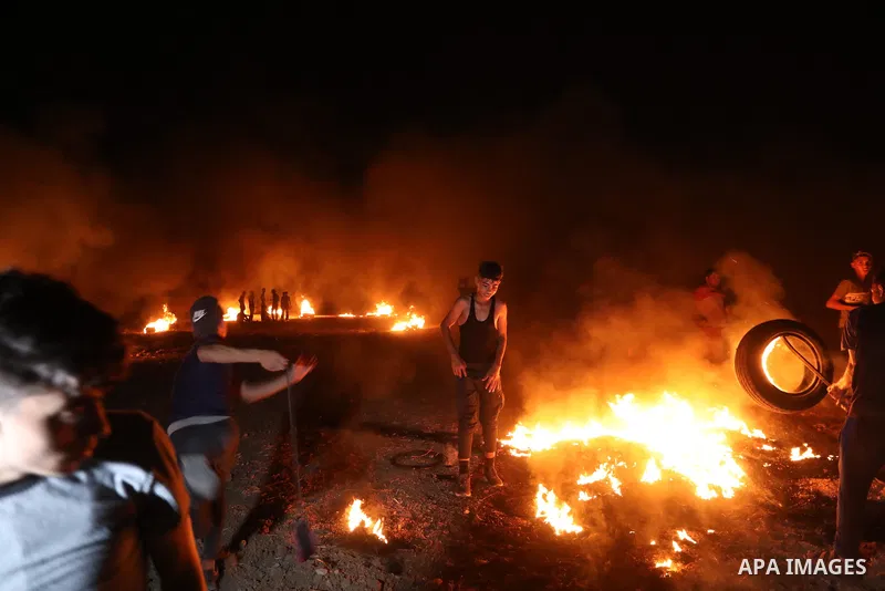 Members of Palestinian protesters calling themselves the "night confusion units", burns tires as they gather near the Gaza-Israel border east of Gaza city, August 28, 2019. Hundreds of Palestinian protesters, have been o...