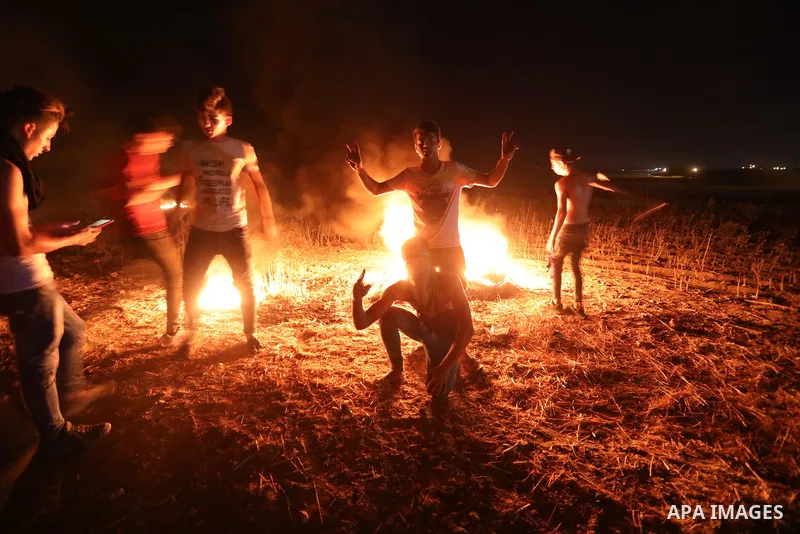 Members of Palestinian protesters calling themselves the "night confusion units", burns tires as they gather near the Gaza-Israel border east of Gaza city, August 28, 2019. Hundreds of Palestinian protesters, have been o...