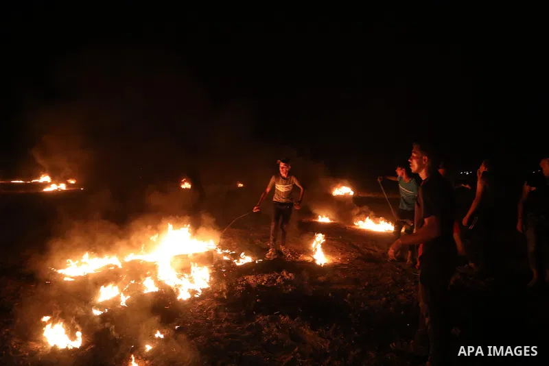 Members of Palestinian protesters calling themselves the "night confusion units", burns tires as they gather near the Gaza-Israel border east of Gaza city, August 28, 2019. Hundreds of Palestinian protesters, have been o...