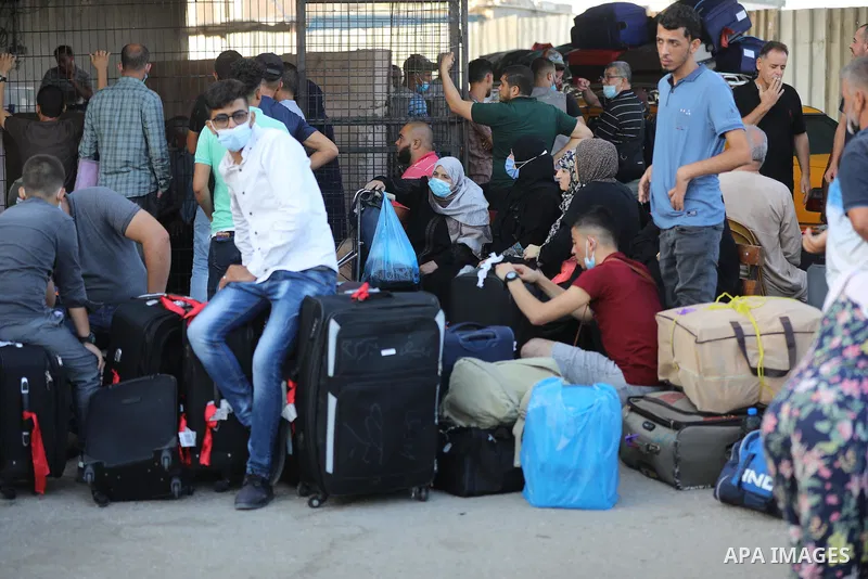 Palestinians wearing protective masks amid the COVID-19 pandemic, as they wait for travel permits to cross into Egypt through the Rafah border crossing, in Rafah in the southern of Gaza Strip, on August 29, 2021. Egypt o...