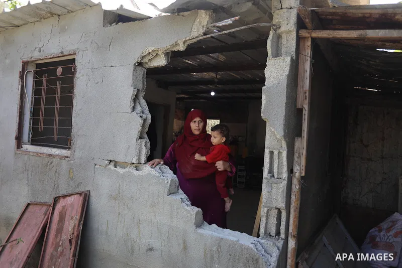 A Palestinian family inspect their home destroyed by Israeli strikes, in Beit Hanoun, northern Gaza Strip on August 29, 2021. Israeli fighter jets attacked two locations in Gaza late last night, resulting in physical dam...