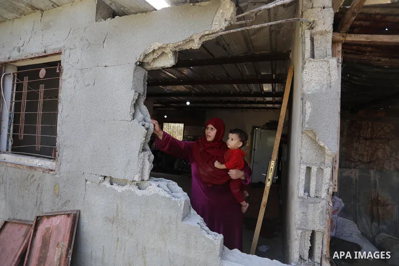 A Palestinian family inspect their home destroyed by Israeli strikes, in Beit Hanoun, northern Gaza Strip on August 29, 2021. Israeli fighter jets attacked two locations in Gaza late last night, resulting in physical dam...