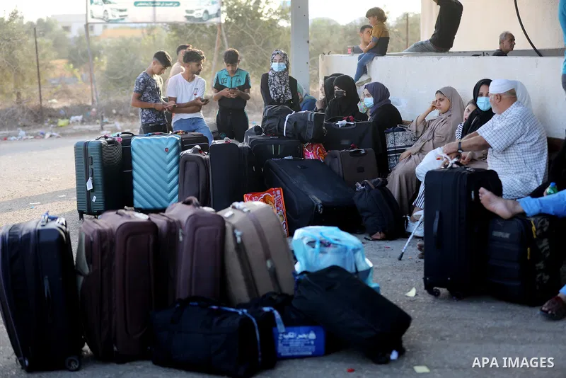 Palestinians wearing protective masks amid the COVID-19 pandemic, as they wait for travel permits to cross into Egypt through the Rafah border crossing, in Rafah in the southern of Gaza Strip, on August 29, 2021. Egypt o...