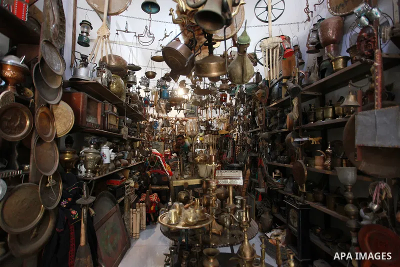 A Palestinian seller displays old copper coins and dozens of valuable antiques, at his Antica Store, in Gaza city on September 1, 2021. In the Gaza Strip, caring for antiquities is not common amid the high poverty and un...